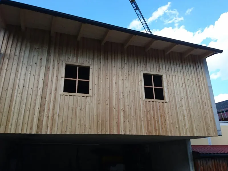 Wirtschaftsgebäude in Holzriegelbauweise mit sib. Lärchen Deckleistenschalung